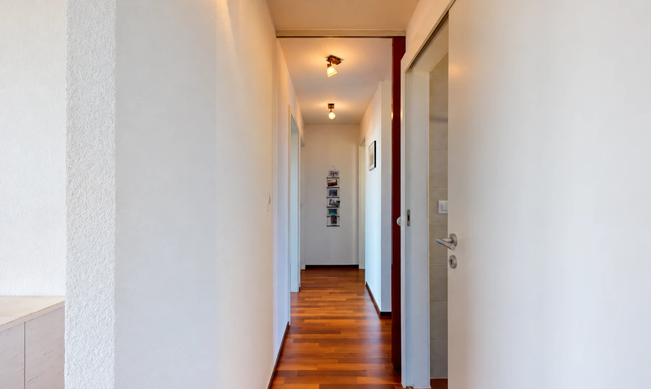 couloir avec sol en finition bois, wood finish floor, inside property, cloison sèche, et drywall