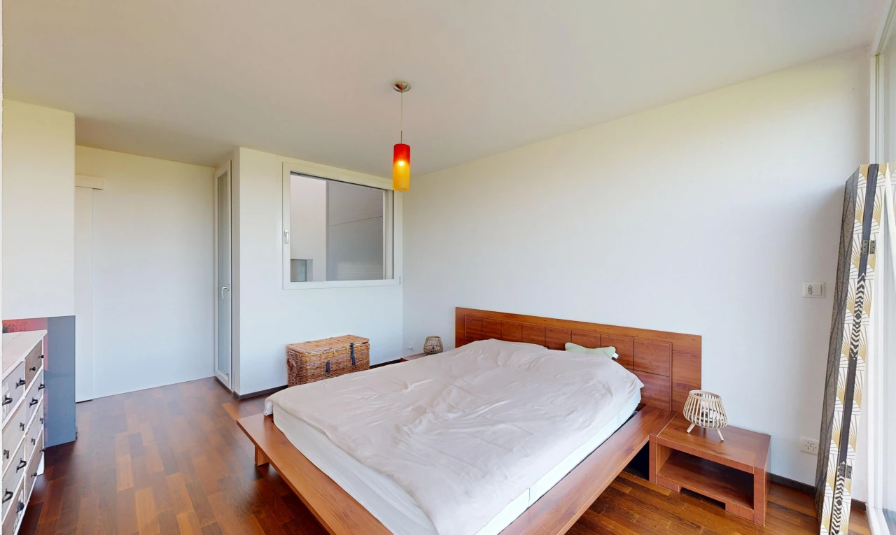 chambre avec éclairage suspendu, cloison sèche, drywall, sol en finition bois, et wood finish floor