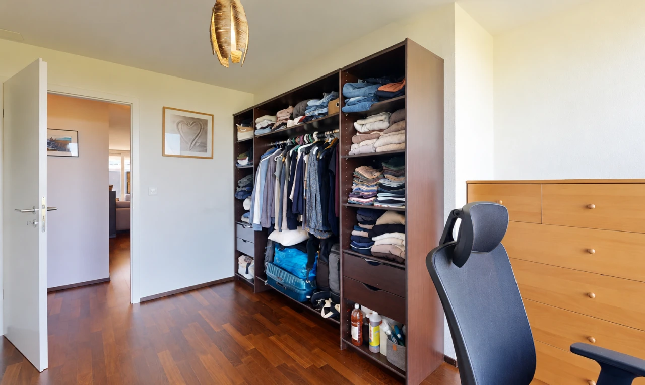 chambre avec dark floor, placard, cloison sèche, drywall, et éclairage suspendu