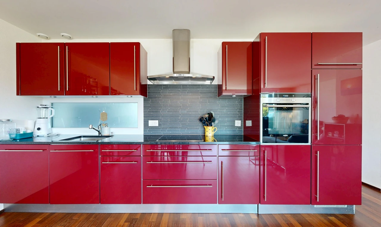cuisine avec four, hotte, dark floor, plans de travail, et dark countertops