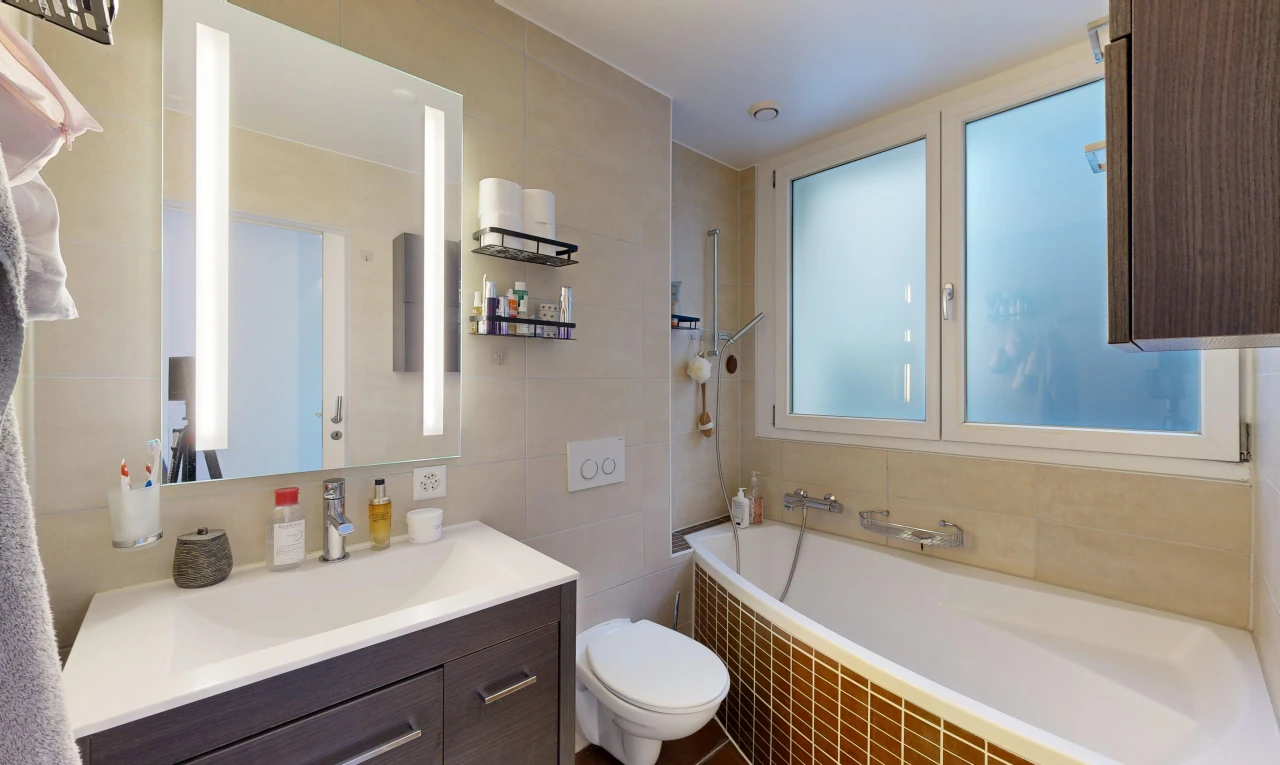 salle de bains avec salle de bain complète, miroir, lavabo (ou coiffeuse selon le contexte), mur en carrelage, et tile wall
