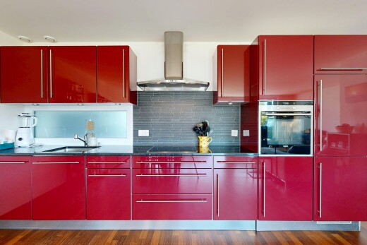 cuisine avec four, hotte, dark floor, plans de travail, et dark countertops