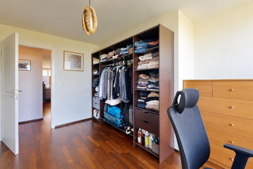 chambre avec dark floor, placard, cloison sèche, drywall, et éclairage suspendu