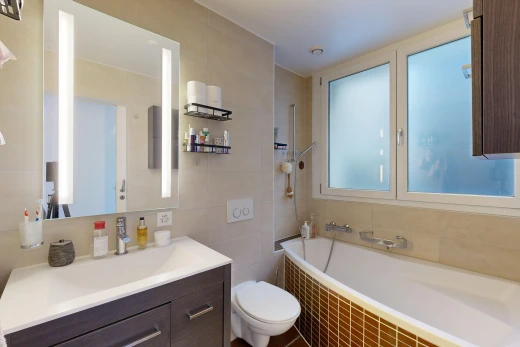 salle de bains avec salle de bain complète, miroir, lavabo (ou coiffeuse selon le contexte), mur en carrelage, et tile wall
