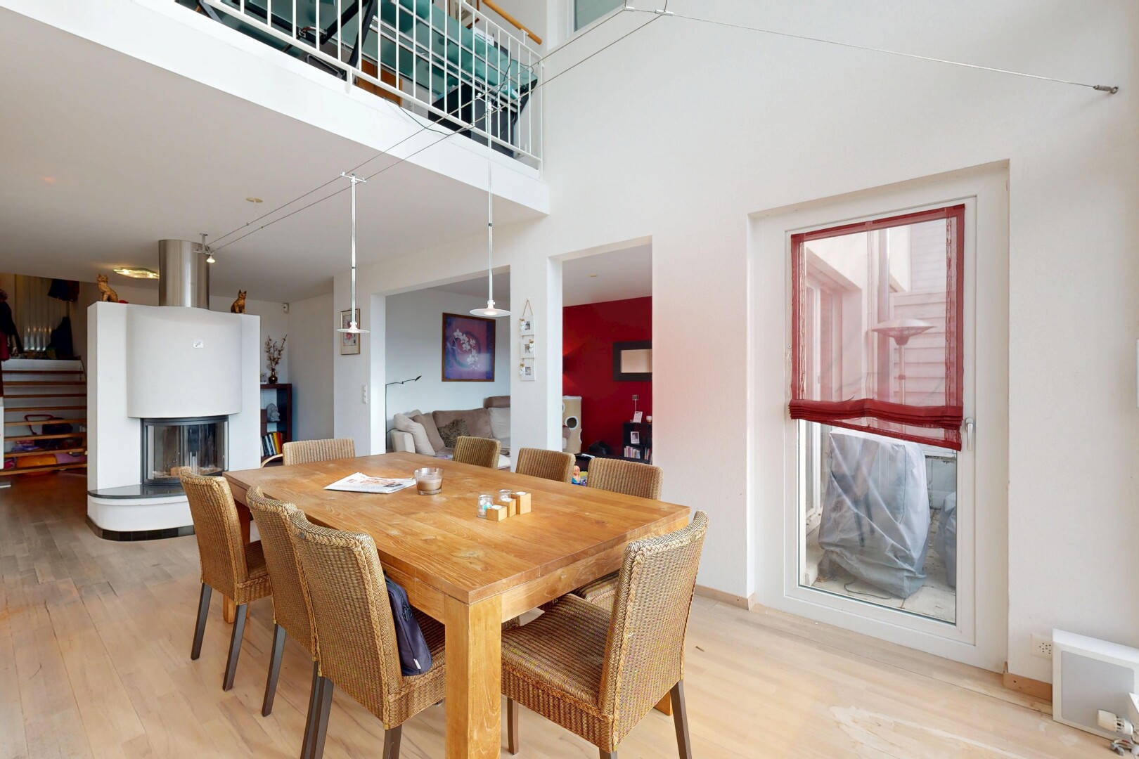 dining room featuring light wood-type flooring and a towering ceiling