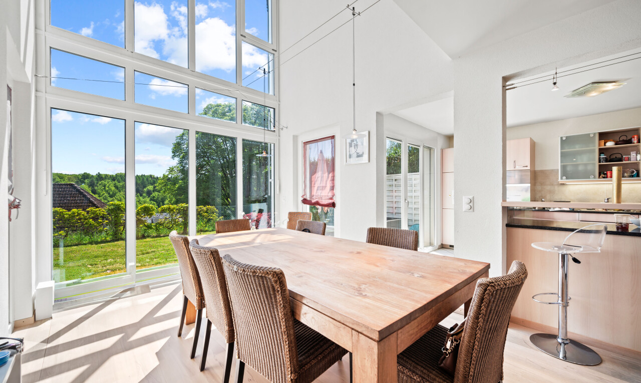 dining space featuring a high ceiling and light wood-style flooring