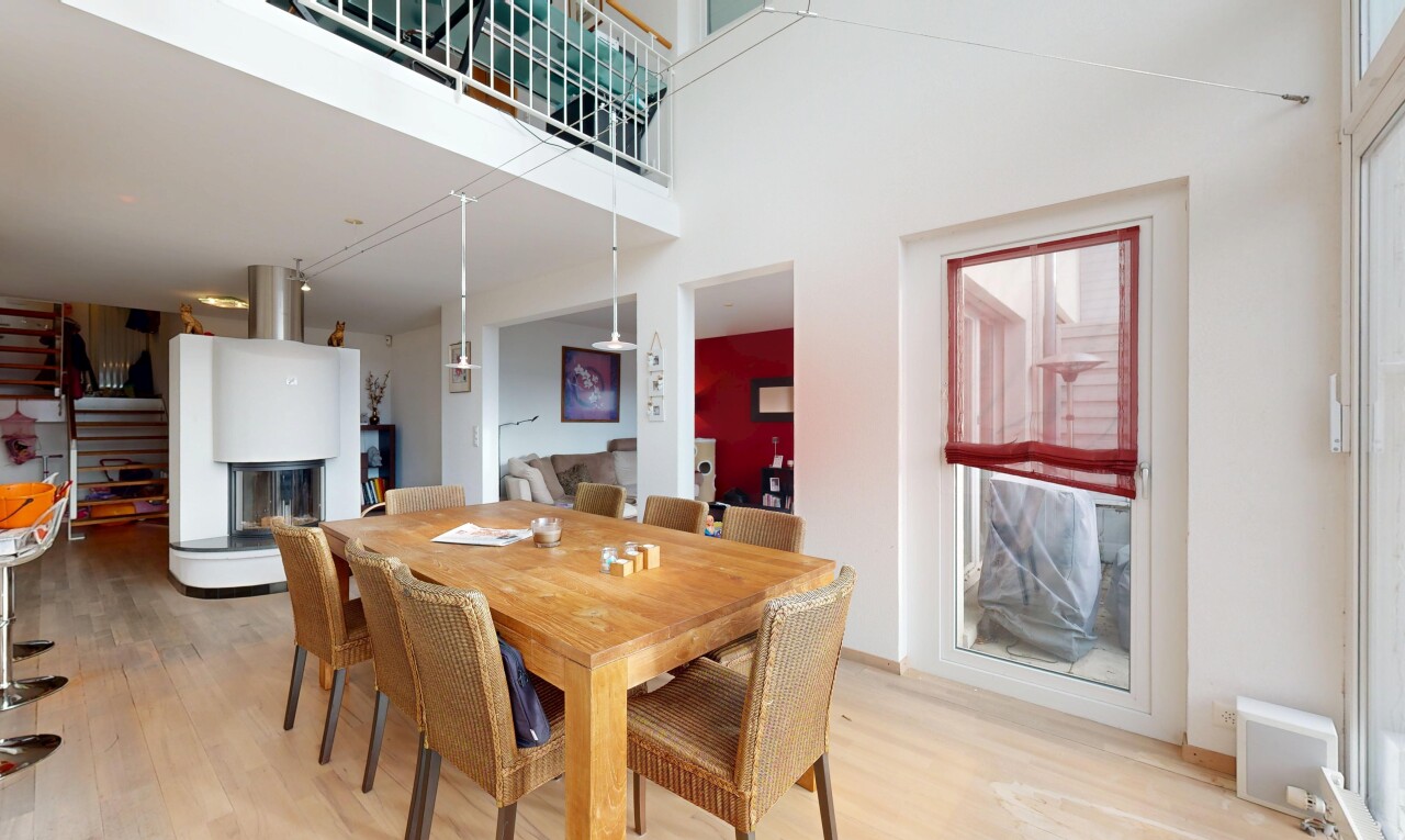 dining room featuring light wood-type flooring and a towering ceiling