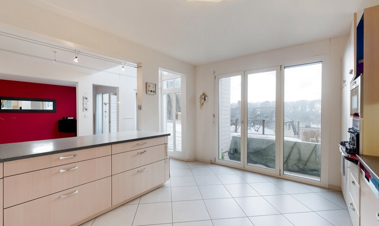 kitchen featuring light tile patterned floors, rail lighting, dark countertops, and stainless steel microwave