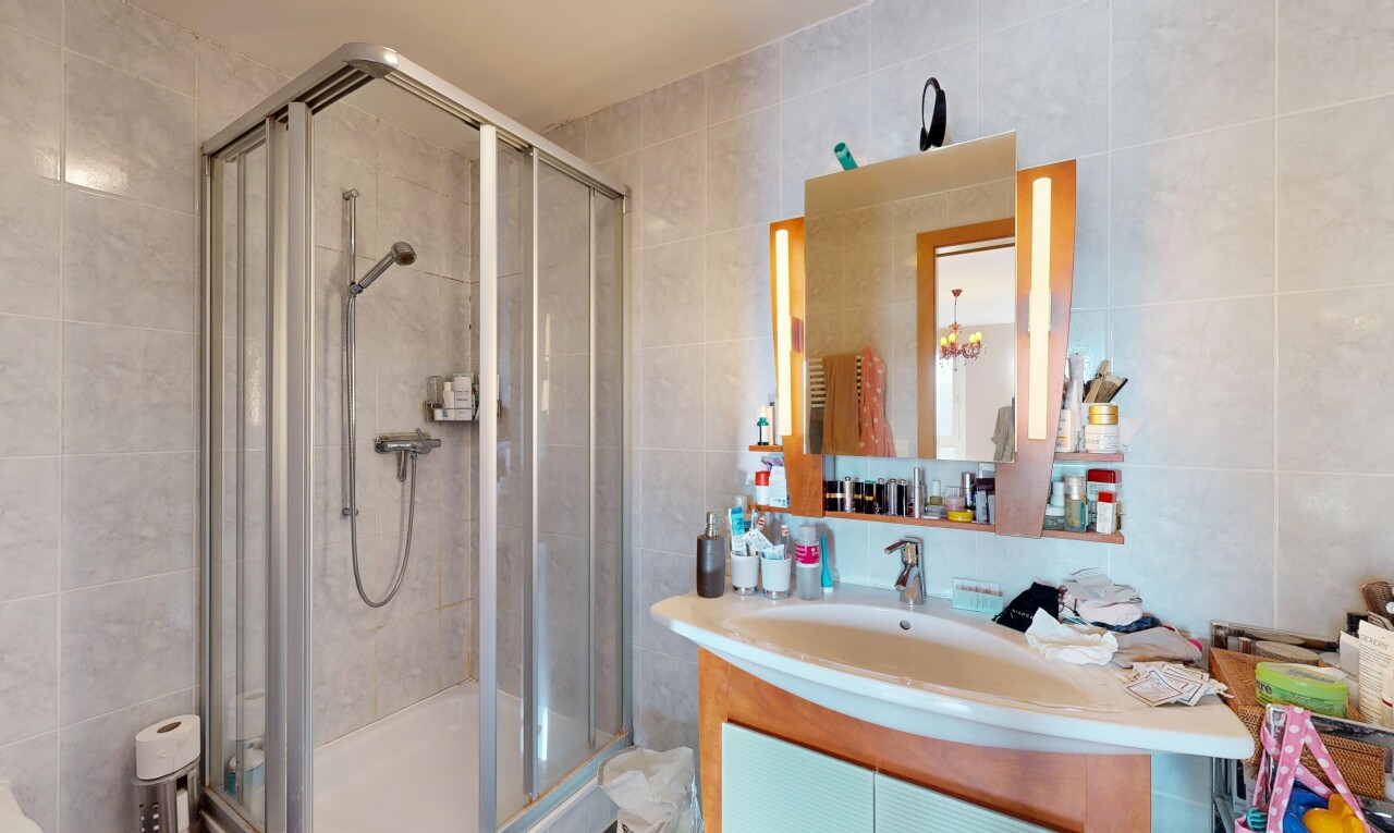full bathroom with tile walls, vanity, and a stall shower