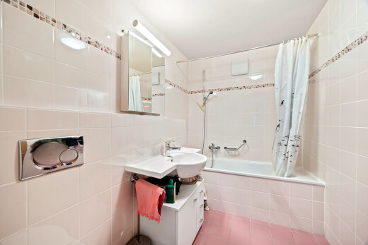 salle de bains avec lavabo (ou coiffeuse selon le contexte), mur en carrelage, tile wall, miroir, et douche-bain combinés