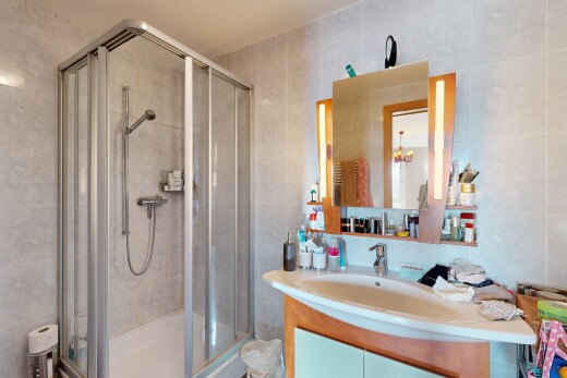 salle de bains avec mur en carrelage, tile wall, lavabo (ou coiffeuse selon le contexte), salle de bain complète, et miroir