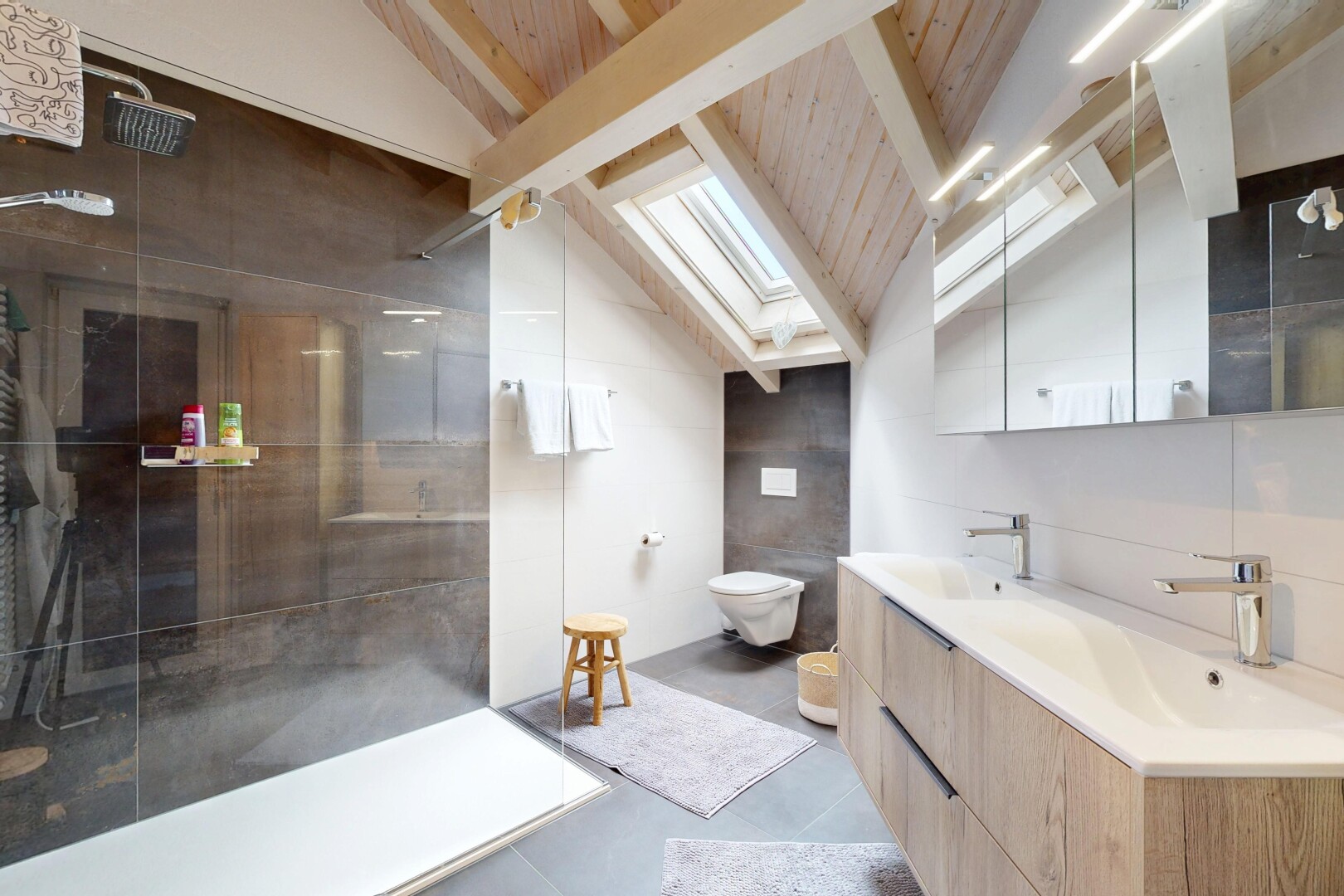 salle de bains avec douche, double vasque, miroir, puits de lumière, et inside property