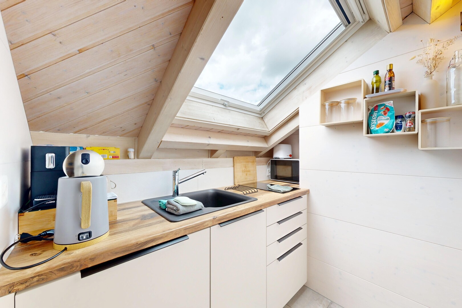 cuisine avec puits de lumière, light countertops, white cabinets, armoires blanches, et inside property