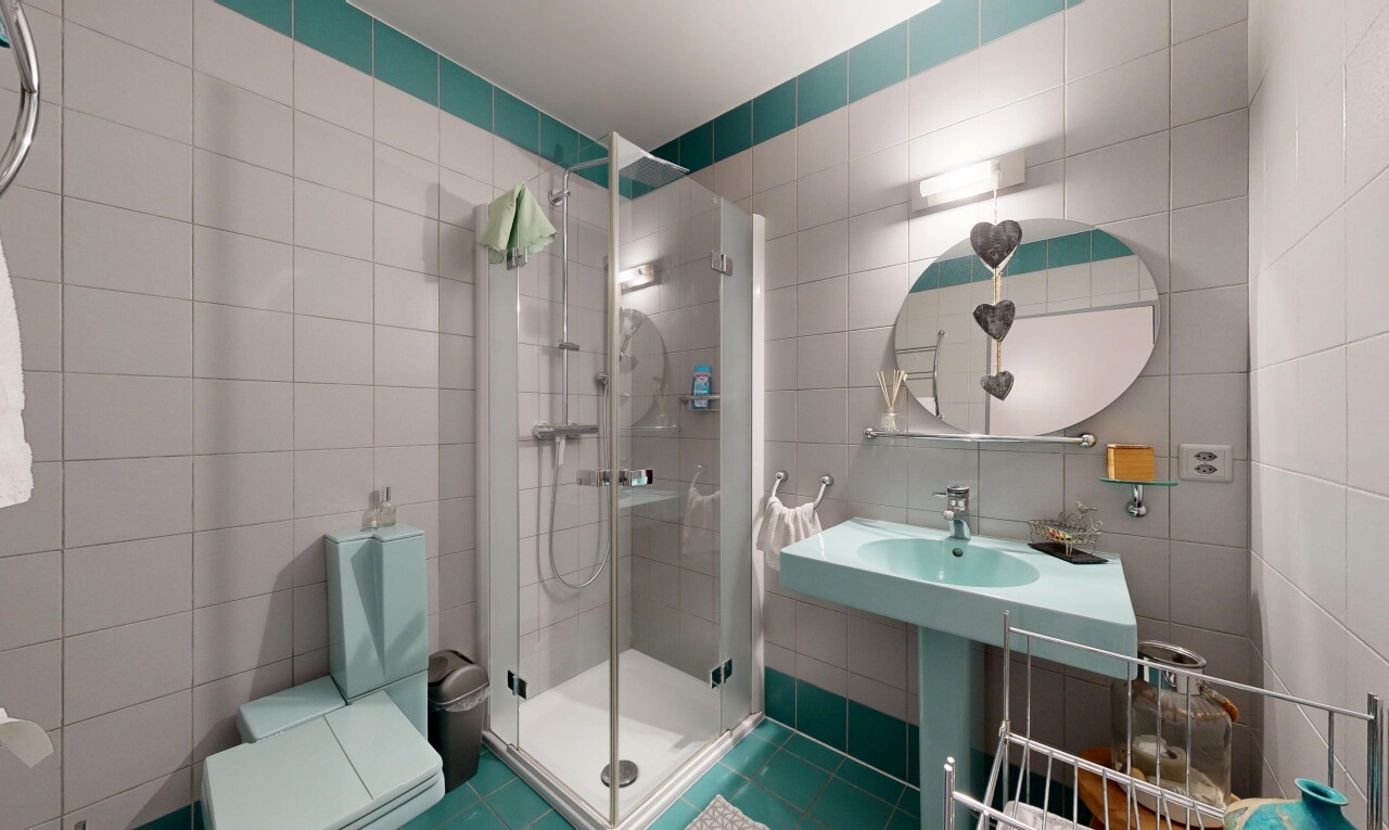 salle de bains avec miroir, douche, mur en carrelage, tile wall, et inside property