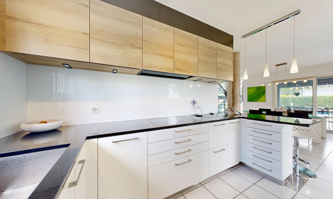 cuisine avec péninsule de cuisine, kitchen peninsula, dark countertops, sol en carrelage, et tile floor