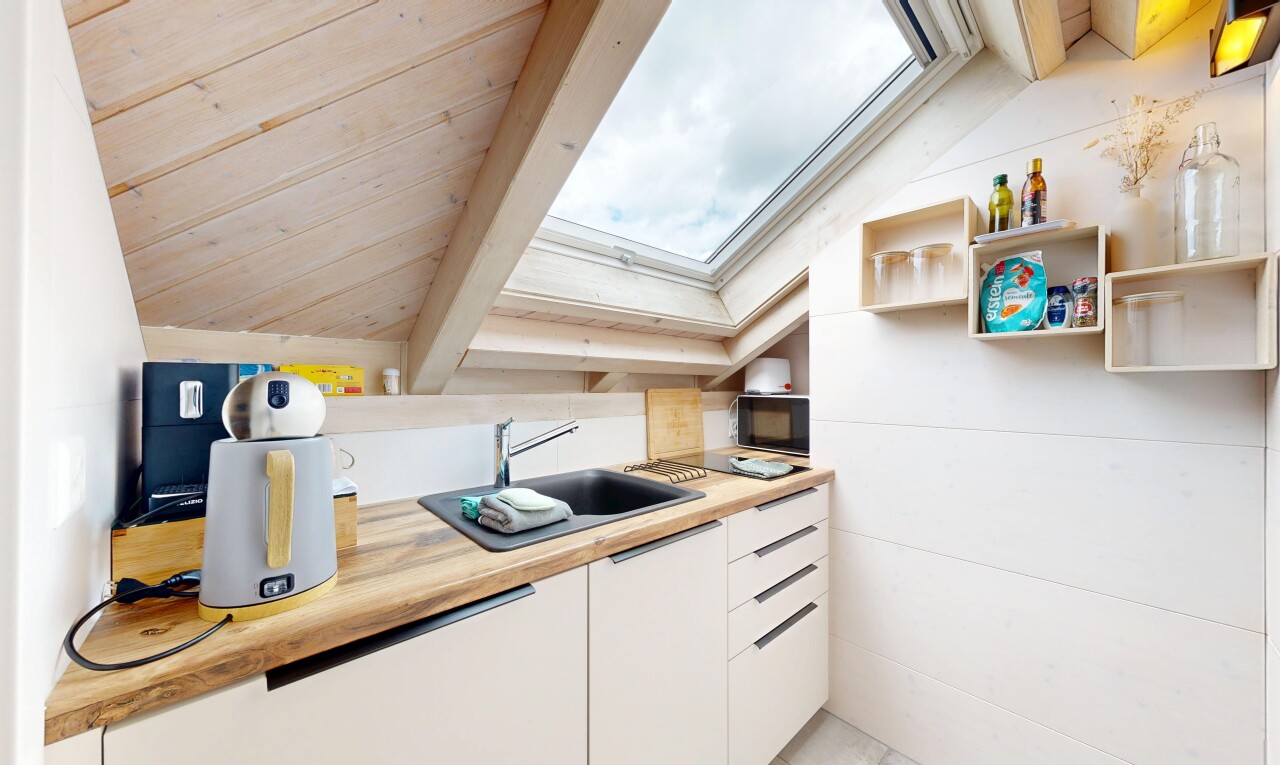 cuisine avec puits de lumière, light countertops, white cabinets, armoires blanches, et inside property