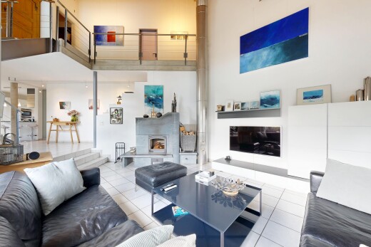 living area with a fireplace with raised hearth, a high ceiling, and light tile patterned floors