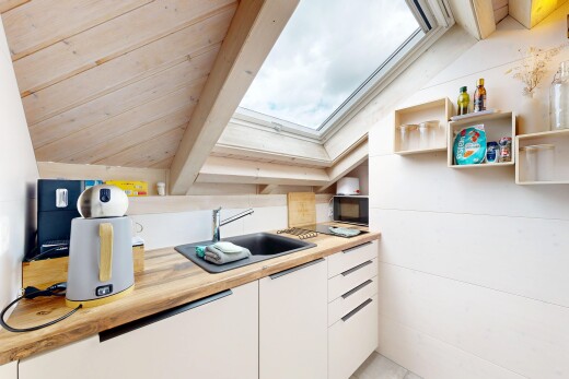 kitchen with a skylight, white cabinets, butcher block countertops, lofted ceiling, and black microwave