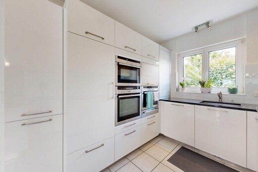 kitchen with white cabinetry, light tile patterned flooring, dark countertops, and stainless steel double oven