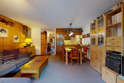 salon / salle à manger avec wood wall, mur en bois, inside property, carpet, et moquette