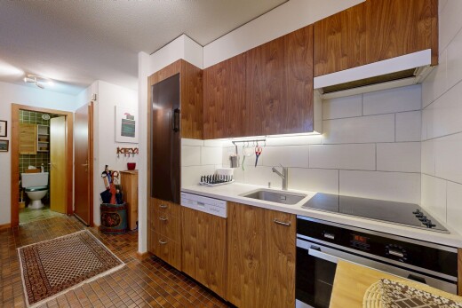 cuisine avec four, armoires marron moyen, hotte, dosseret, et backsplash