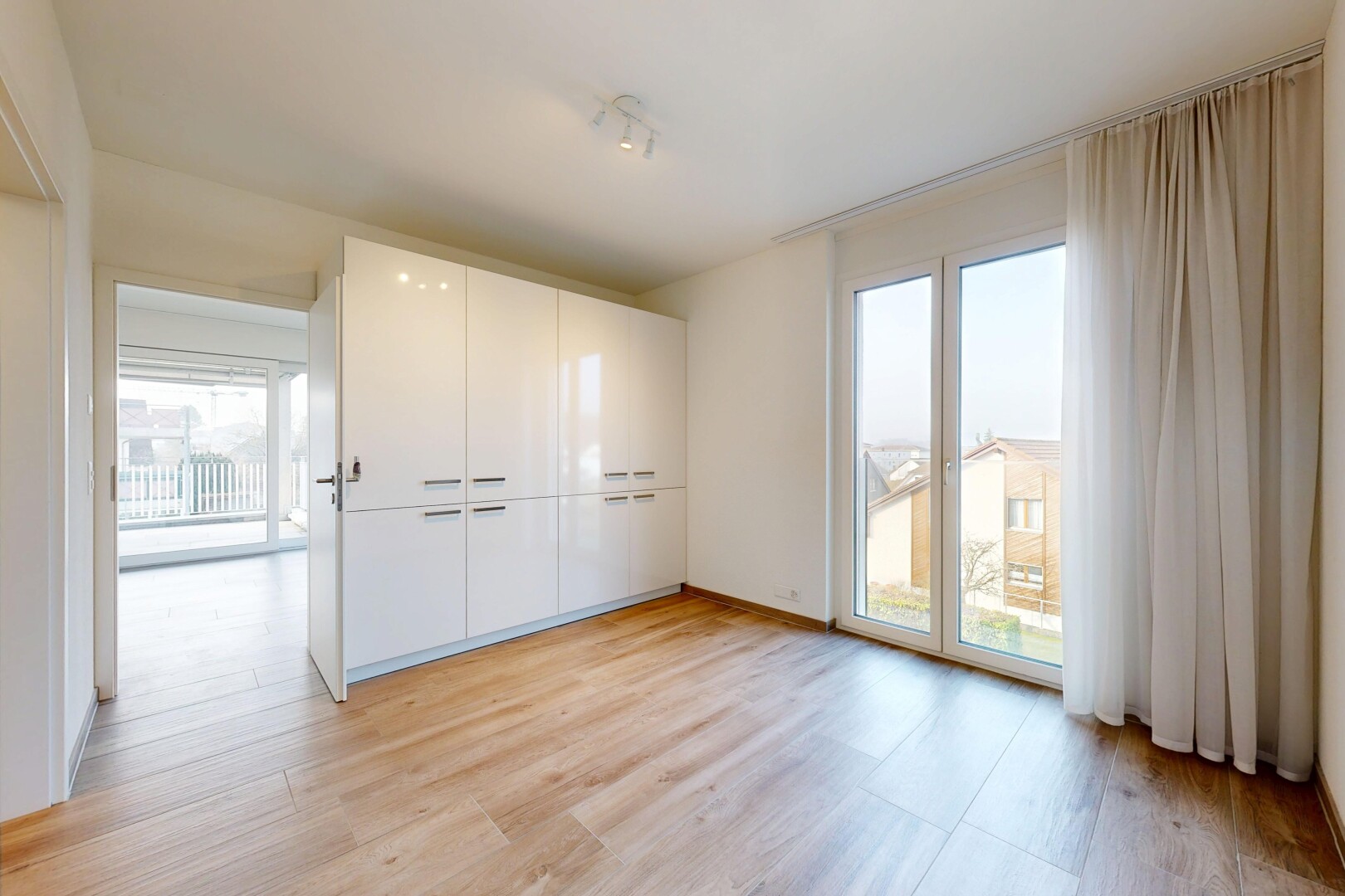 pièce vide avec light floor, inside property, wood finish floor, sol en finition bois, et natural light