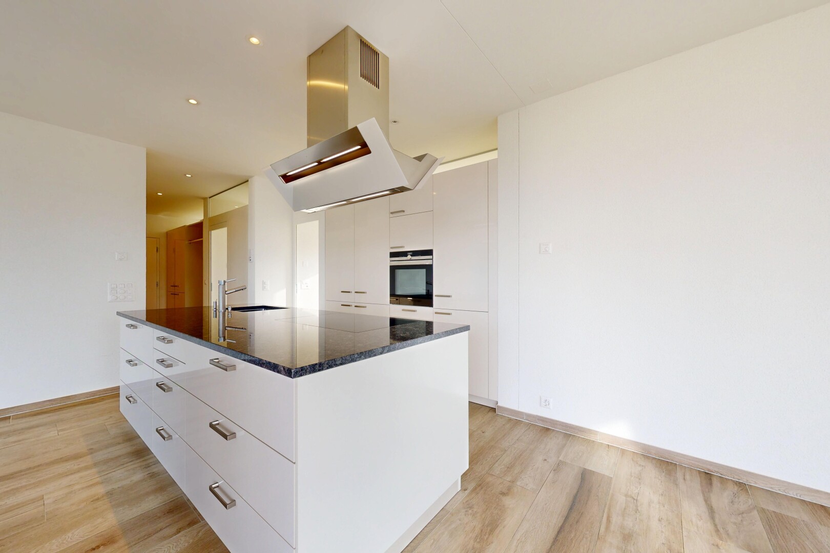 cuisine avec dark countertops, light floor, hotte, armoires blanches, et white cabinets