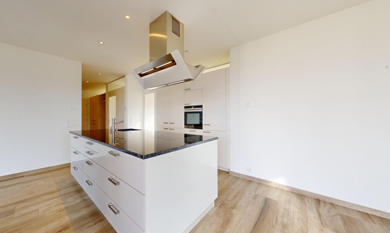 cuisine avec dark countertops, light floor, hotte, armoires blanches, et white cabinets