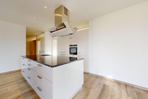 cuisine avec dark countertops, light floor, hotte, armoires blanches, et white cabinets