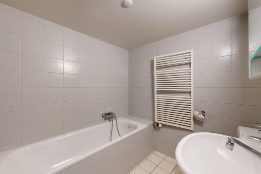 salle de bains avec mur en carrelage, tile wall, radiateur, tile tub, et chauffe-serviettes