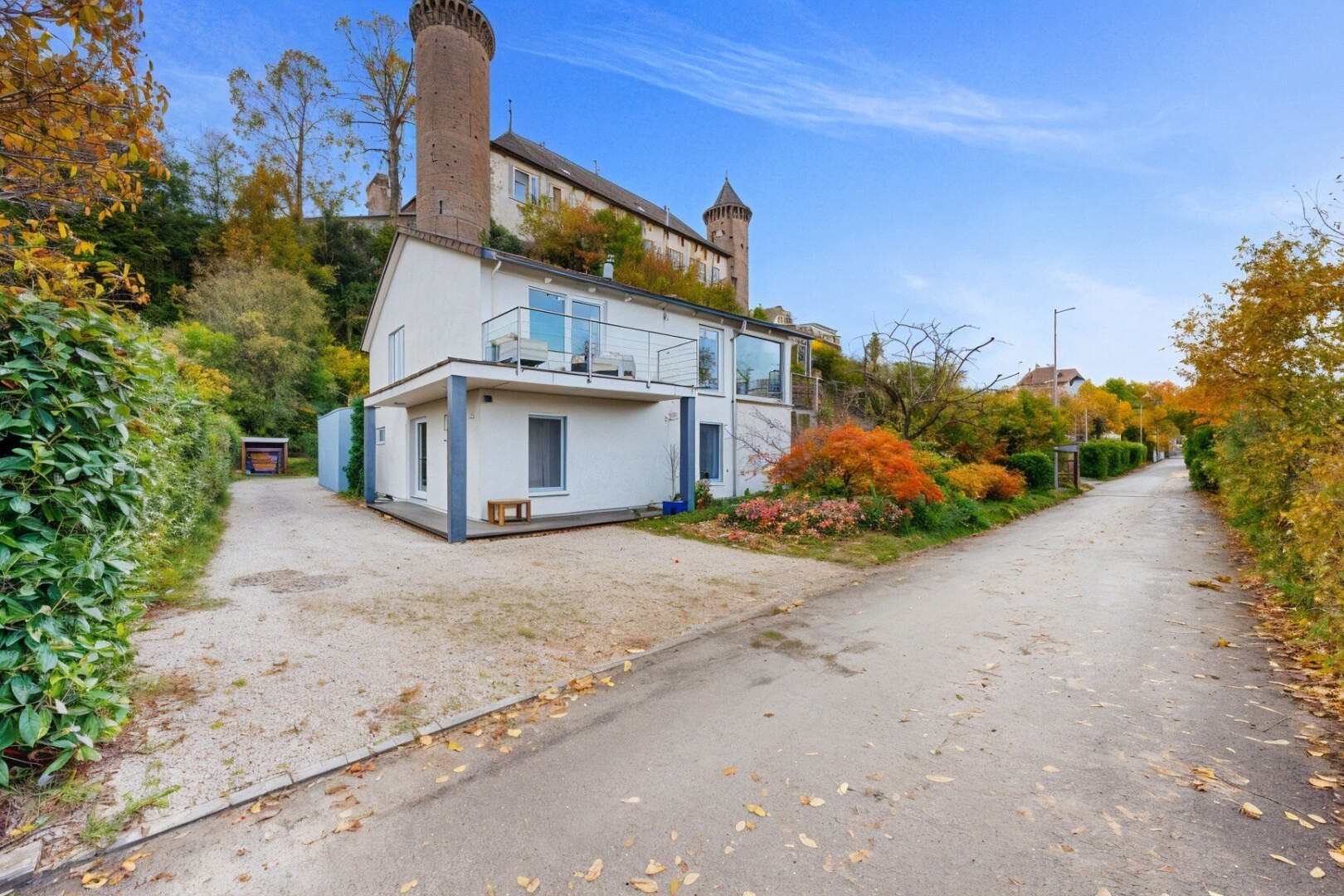 façade avec day time, property visible, bardage en stuc, cheminée, et aire de stationnement