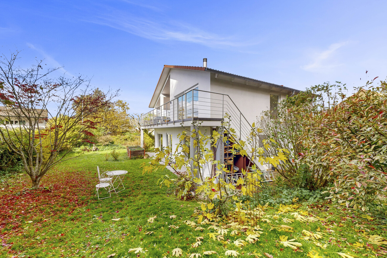 façade avec pelouse, bardage en stuc, property visible, day time, et terrasse