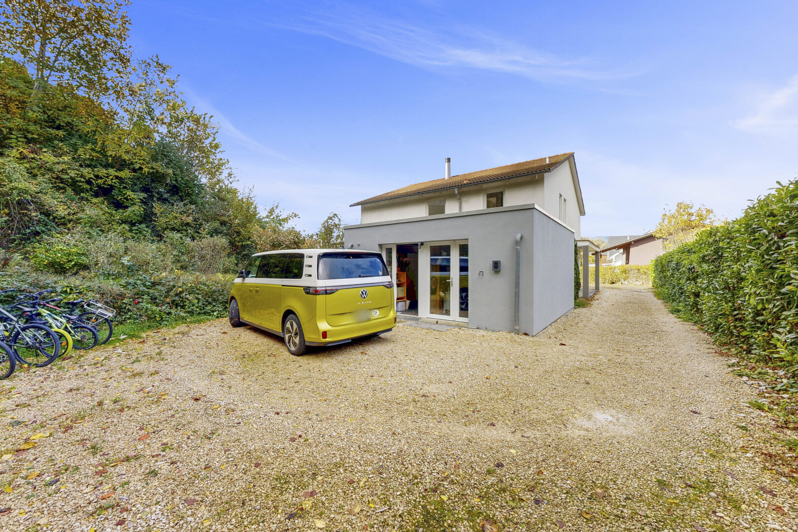 façade avec aire de stationnement, day time, bardage en stuc, et property visible