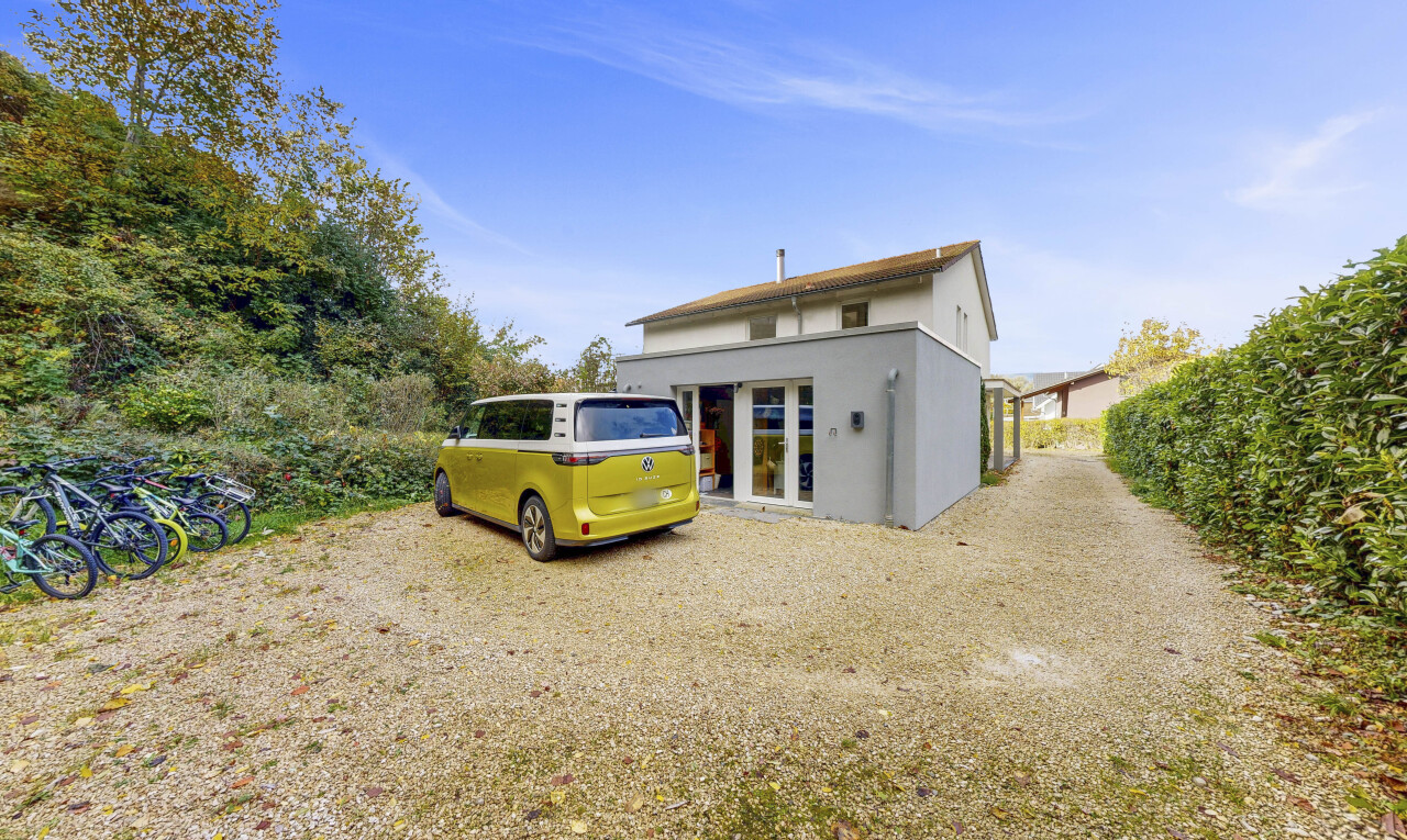façade avec aire de stationnement, day time, bardage en stuc, et property visible