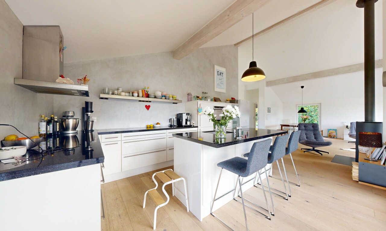cuisine avec éclairage suspendu, sol en finition bois, wood finish floor, plafond à poutres, et beamed ceiling