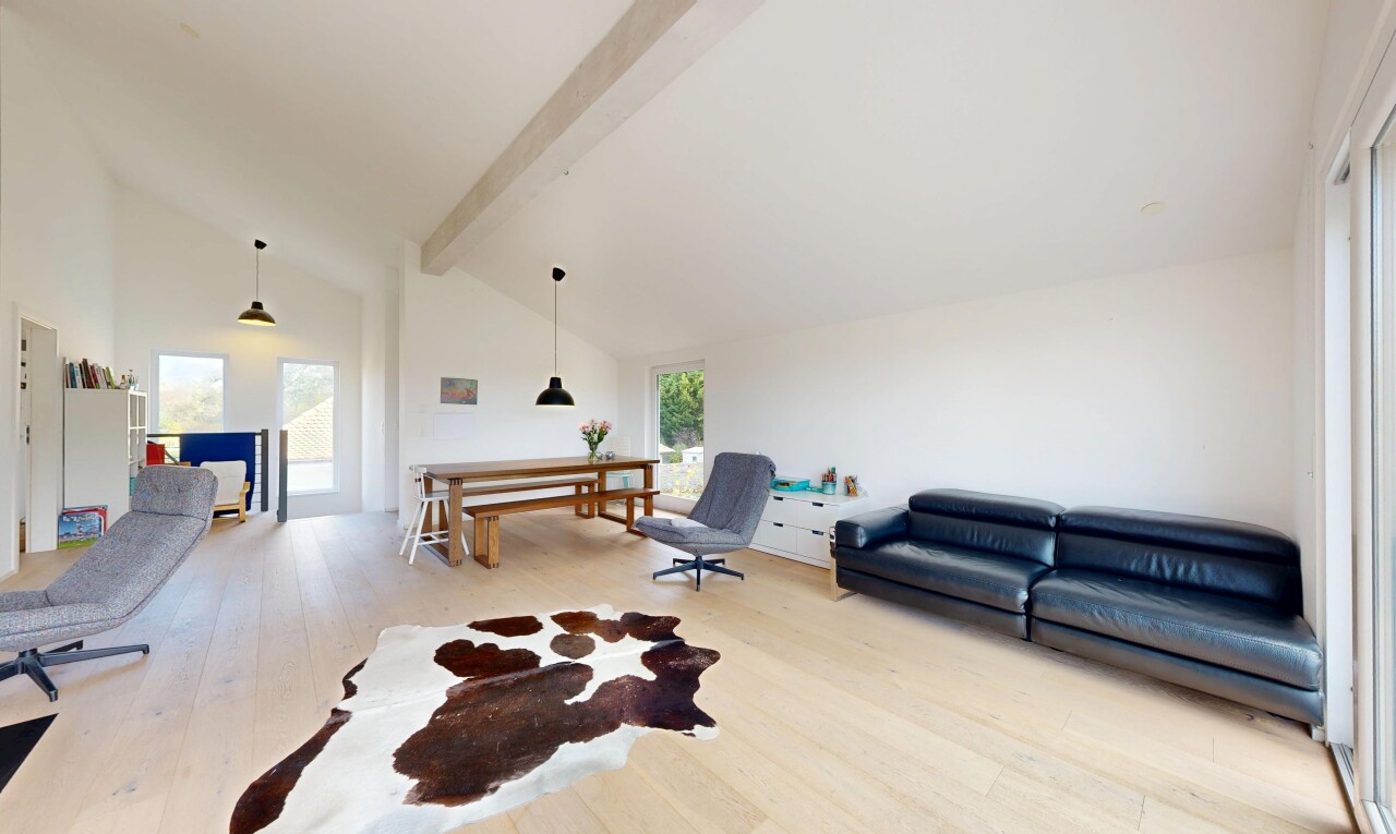 salon avec beamed ceiling, plafond à poutres, vaulted ceiling, plafond voûté, et wood finish floor