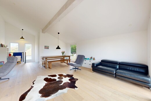 wohnzimmer mit beamed ceiling, balkendecke, vaulted ceiling, dachschräge, und wood finish floor