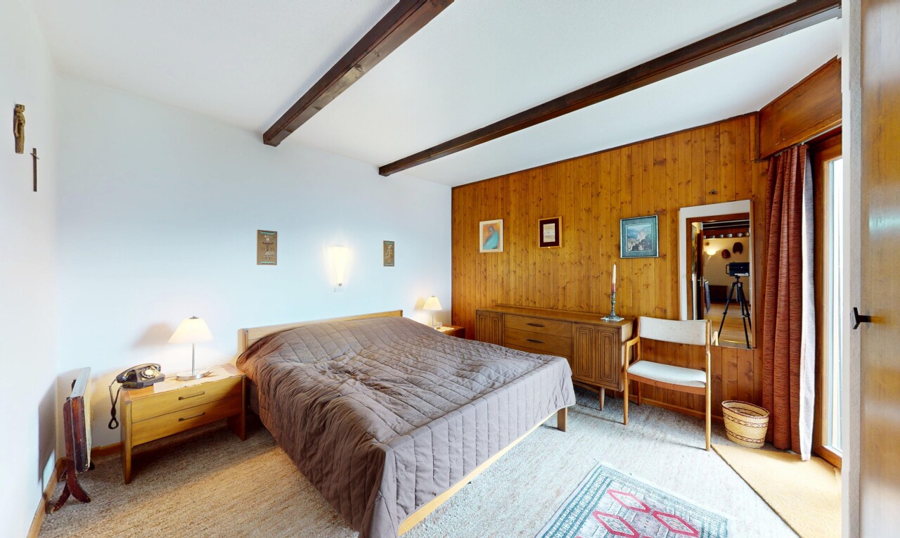 zimmer / schlafzimmer mit beamed ceiling, balkendecke, carpet, teppich, und wood wall