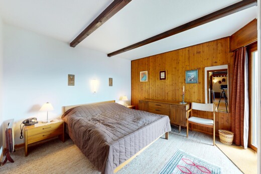 zimmer / schlafzimmer mit beamed ceiling, balkendecke, carpet, teppich, und wood wall