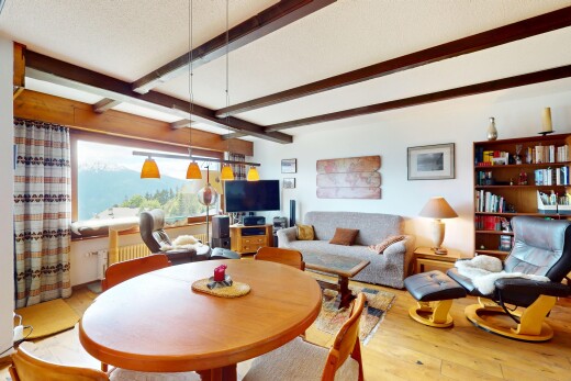 living / dining room with beamed ceiling and hardwood / wood-style floors