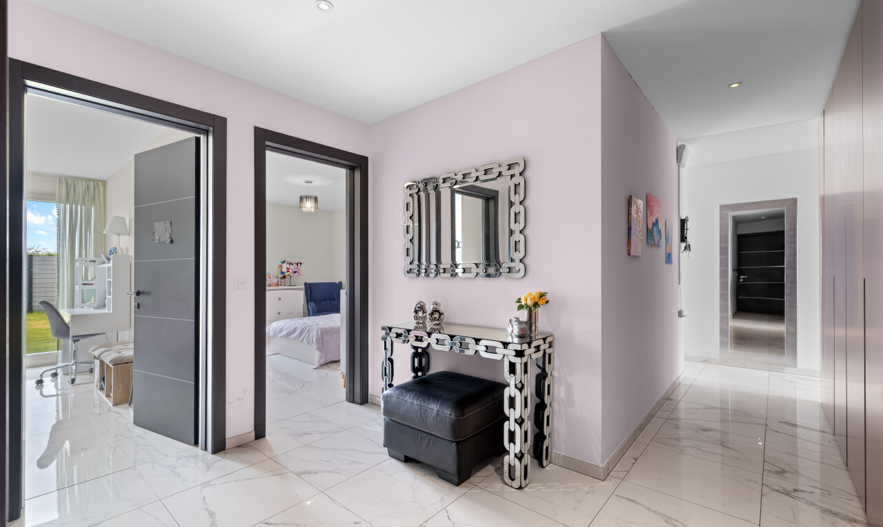 couloir avec plinthes murales, baseboards wall, sol en finition marbre, marble finish floor, et inside property