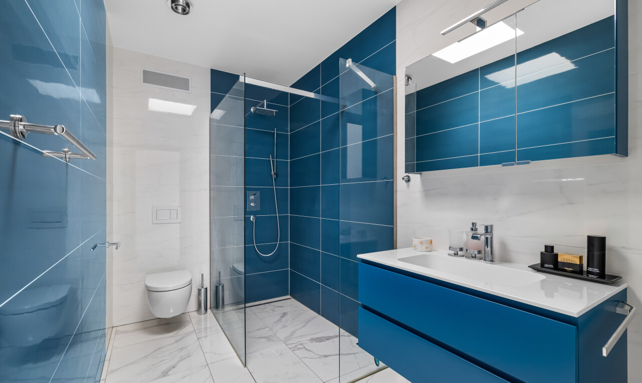 salle de bains avec douche, miroir, lavabo (ou coiffeuse selon le contexte), salle de bain complète, et mur en carrelage
