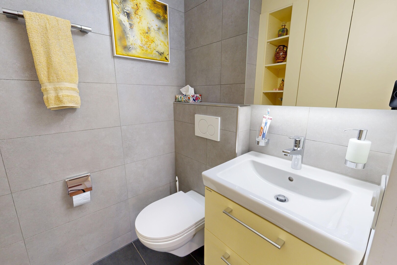 salle de bains avec mur en carrelage, tile wall, miroir, lavabo (ou coiffeuse selon le contexte), et toilette