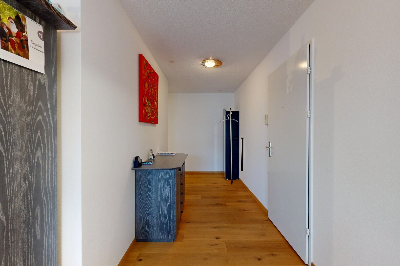 couloir avec cloison sèche, drywall, inside property, sol en finition bois, et wood finish floor