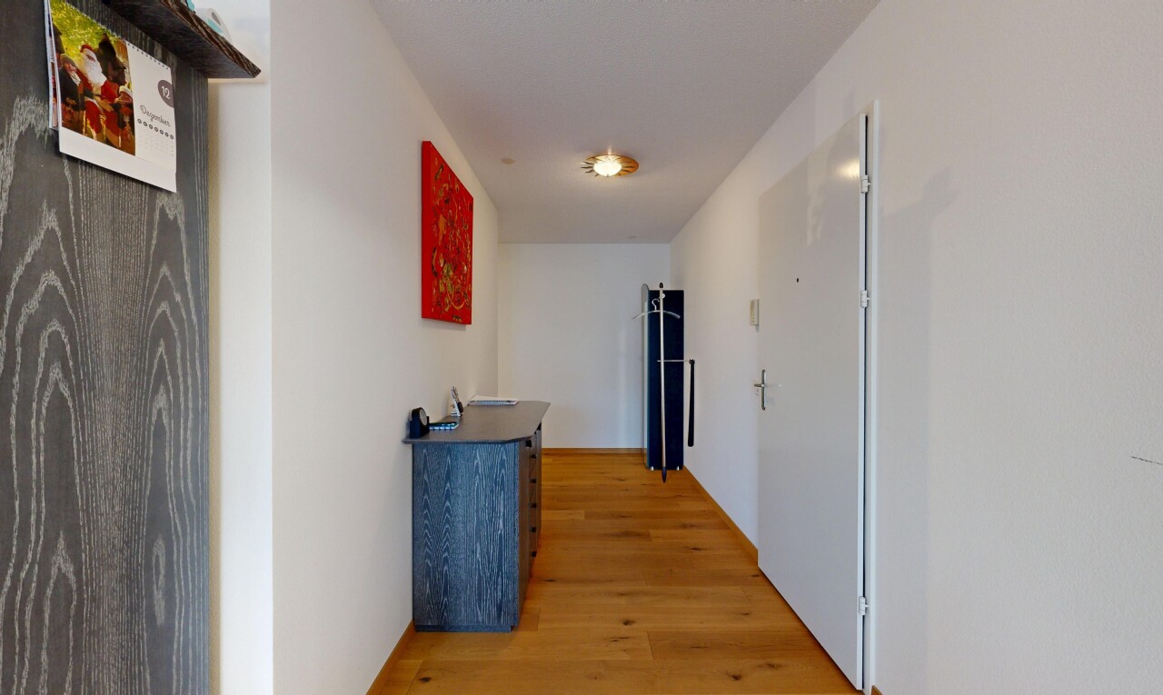 couloir avec cloison sèche, drywall, inside property, sol en finition bois, et wood finish floor