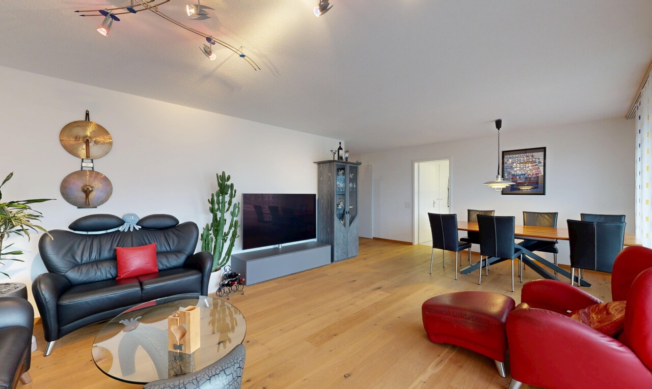 salon / salle à manger avec télévision, cloison sèche, drywall, sol en finition bois, et wood finish floor