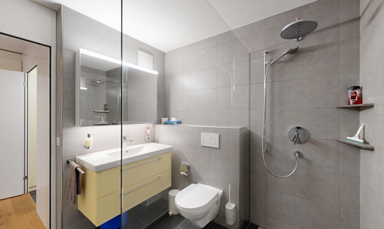 salle de bains avec douche, salle de bain complète, miroir, lavabo (ou coiffeuse selon le contexte), et inside property