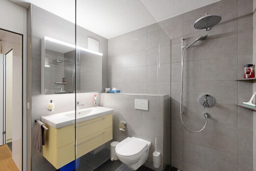 salle de bains avec douche, salle de bain complète, miroir, lavabo (ou coiffeuse selon le contexte), et inside property