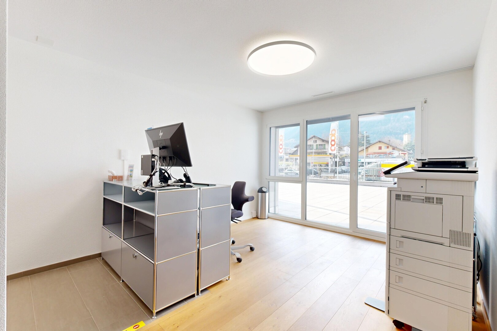 bureau avec télévision, cloison sèche, espace bureau, plinthes murales, et lumière naturelle