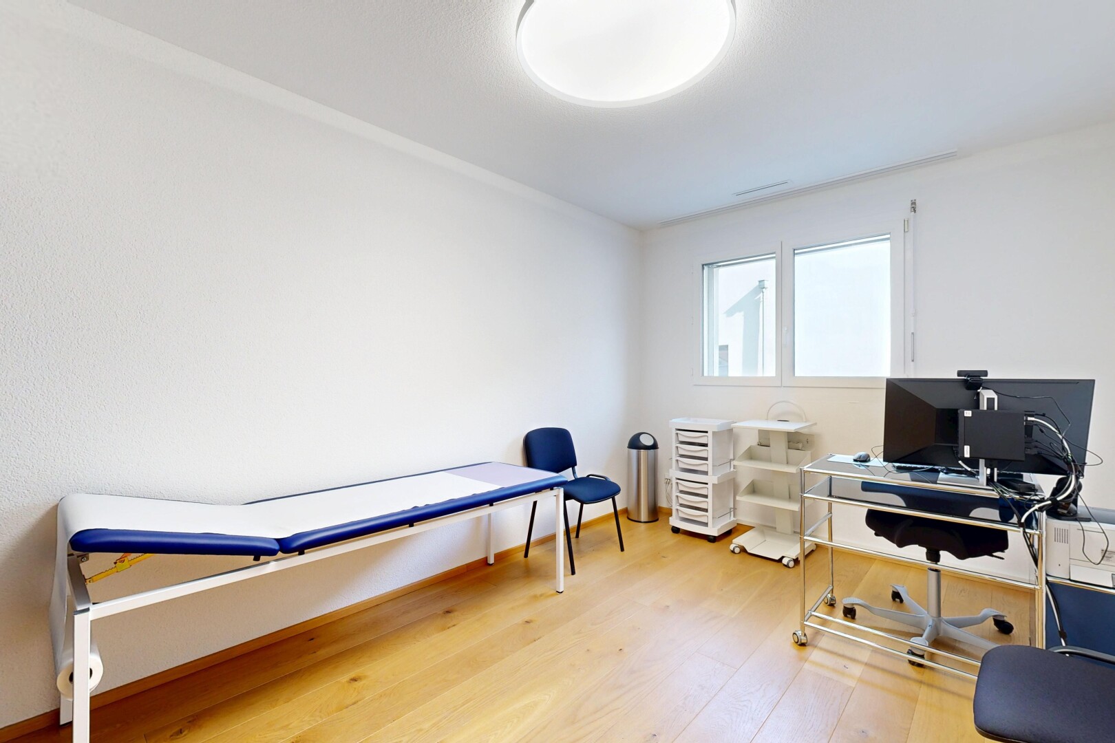 chambre avec sol en finition bois, télévision, espace bureau, lumière naturelle, et cloison sèche
